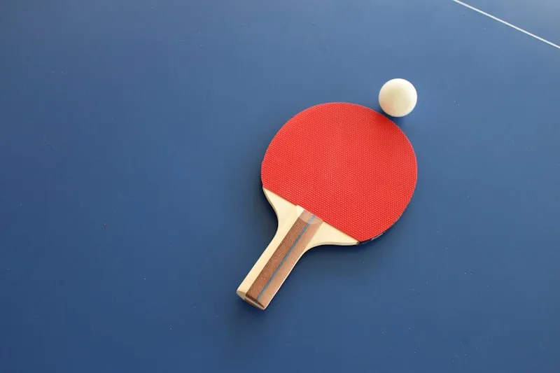 Table de ping-pong avec raquettes et balle prêtes pour une partie
