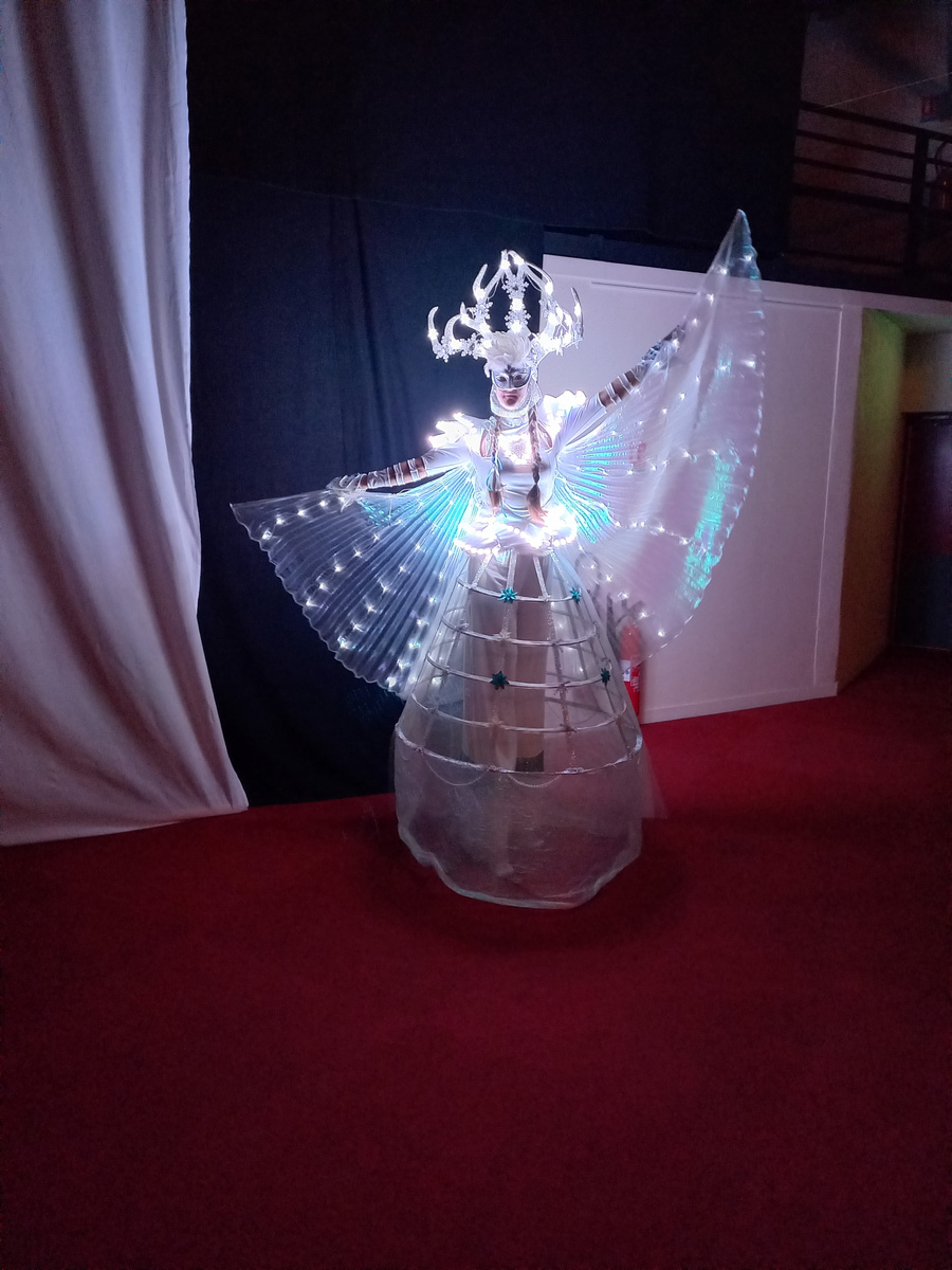Fée géante lumineuse en déambulation dans une galerie marchande