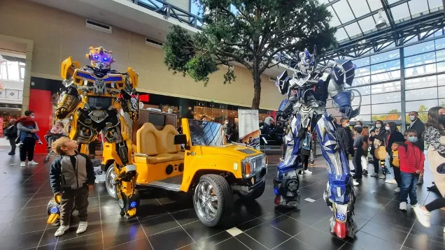 Robots géants lumineux à LEDs en déambulation devant des visiteurs