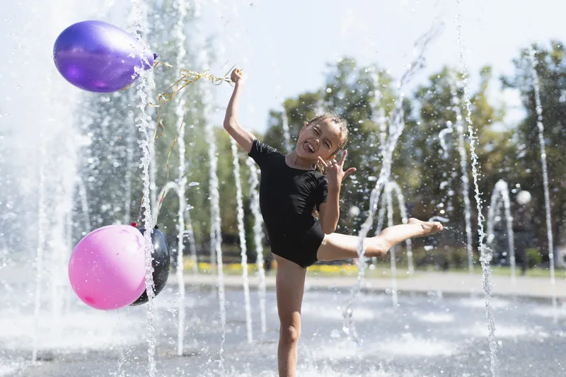 Enfants qui jouent dans une zone de jeux d'eau avec jets et brumisateurs